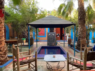 a swimming pool with a tent and two chairs and a table at Riad Dades Birds Lodge in Boumalne