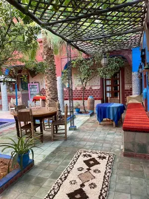 an outdoor patio with a table and chairs and a table and a table at Riad Dades Birds Lodge in Boumalne