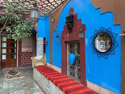 a blue wall with a bench in a courtyard at Riad Dades Birds Lodge in Boumalne