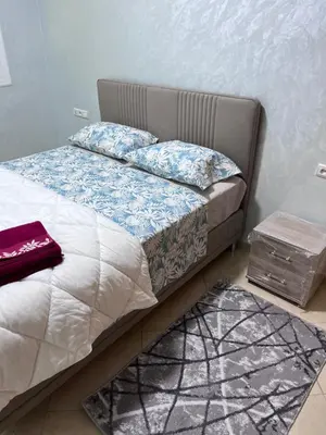 a bedroom with a bed and a nightstand next to it at appartement fes in Fès