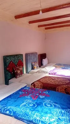 a room with two beds and a blue blanket at Dar Agourzi Café des Epices in Tacheddirt