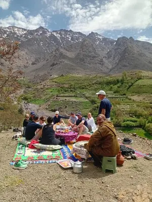 a group of people sitting at a picnic table on a mountain at Dar Agourzi Café des Epices in Tacheddirt