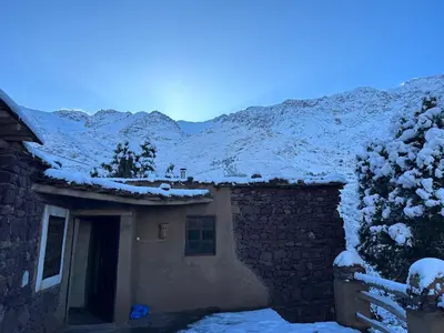 a house with snow on the roof of it at Dar Agourzi Café des Epices in Tacheddirt