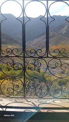 an iron gate with a view of a mountain at Dar Agourzi Café des Epices in Tacheddirt