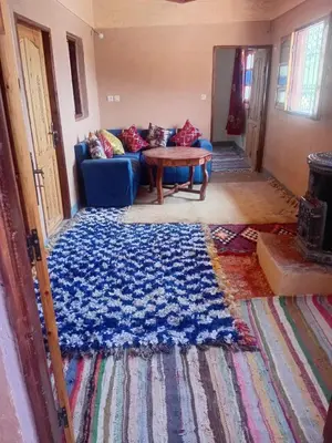 a living room with a blue couch and a table at Dar Agourzi Café des Epices in Tacheddirt
