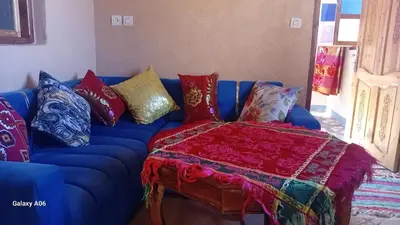 a blue couch with colorful pillows on it at Dar Agourzi Café des Epices in Tacheddirt