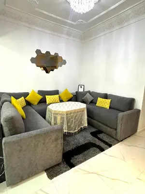 a living room with a couch and a table at Appartement pour les familles in Fès