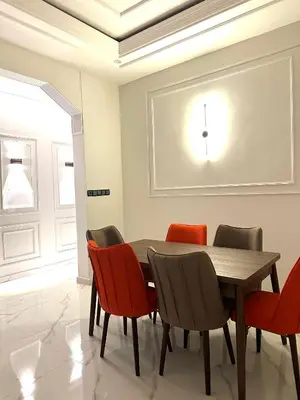 a dining room with a wooden table and red chairs at Appartement pour les familles in Fès