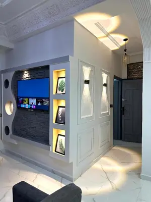a living room with a wall with a tv and a couch at Appartement pour les familles in Fès