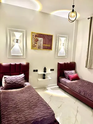 a bedroom with two beds and a couch at Appartement pour les familles in Fès