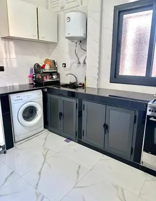 a kitchen with a washer and a washing machine at Appartement pour les familles in Fès