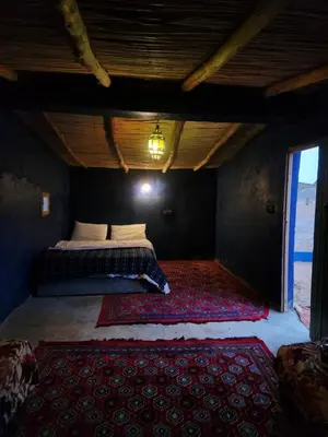 a bedroom with a bed in a room with a red rug at Camping Meteorite in Merzane