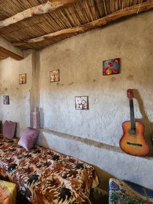 a bedroom with a bed and a guitar on the wall at Camping Meteorite in Merzane