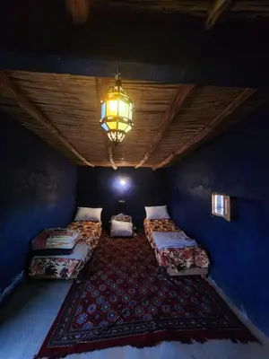 a room with two beds and a chandelier at Camping Meteorite in Merzane