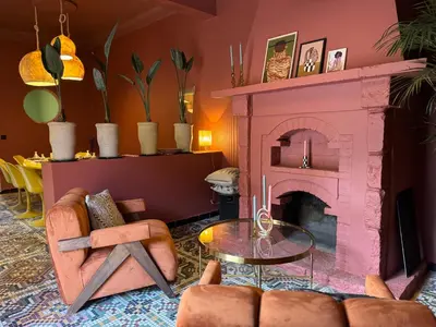 a living room with a pink fireplace and chairs at villa lalla Ourika & heated pool in Oulad Akkou