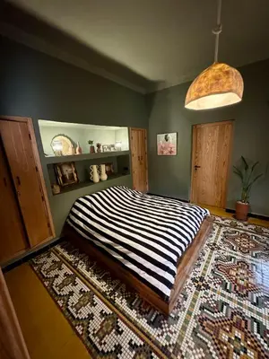 a bedroom with a large bed with a rug at villa lalla Ourika & heated pool in Oulad Akkou