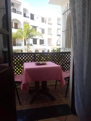 a table with a pink table cloth on a balcony at Chez Nour in Oulad Akkou