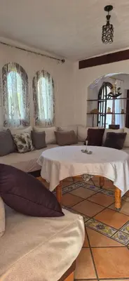 a living room with two tables and a couch at Chez Nour in Oulad Akkou