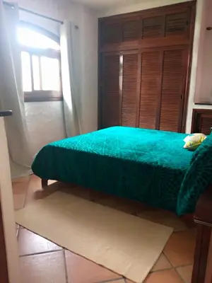 a bedroom with a green bed and a window at Chez Nour in Oulad Akkou