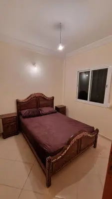 a bedroom with a wooden bed in a room at New apartment fully equipped in Fès
