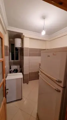 a small kitchen with a refrigerator and a stove at New apartment fully equipped in Fès