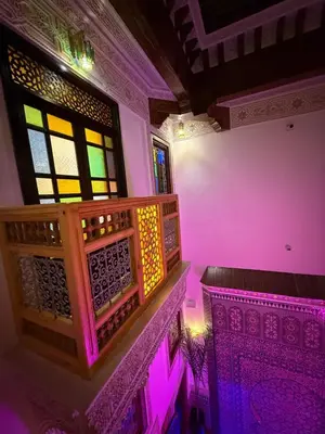 a room with pink and purple lights and windows at Riad Dar ElBellar in Fès