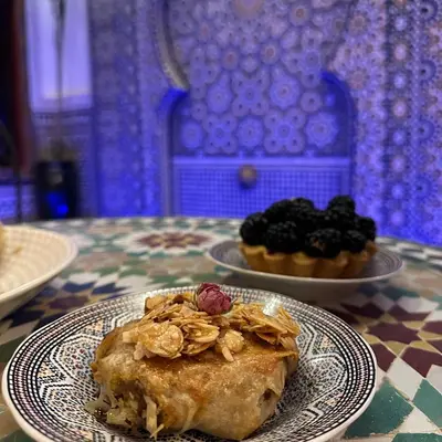 a plate of food on a table with a plate of desserts at Riad Dar ElBellar in Fès