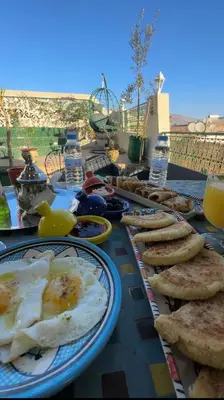 a breakfast table with eggs and bread on it at Riad Dar ElBellar in Fès
