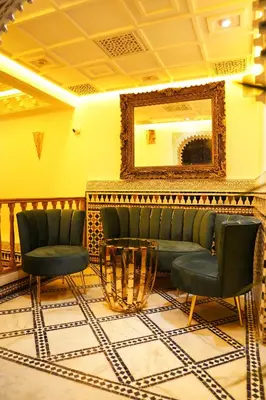 a waiting room with two chairs and a mirror at Riad Dar ElBellar in Fès