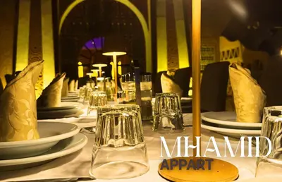 a table with plates and glasses on a table at mhamid hotel in Kasr Bounou