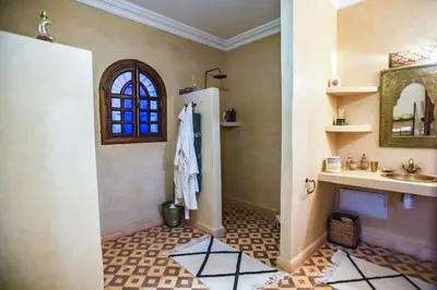 a bathroom with a sink and a mirror at Domaine avec gouvernante 5 chambres, piscine, hamam et ferme pédagogique sur un hectare in Had Abdallah Rhiat