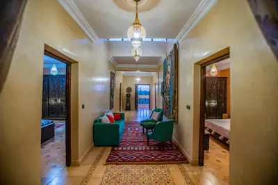 a hallway of a home with green chairs and a rug at Domaine avec gouvernante 5 chambres, piscine, hamam et ferme pédagogique sur un hectare in Had Abdallah Rhiat