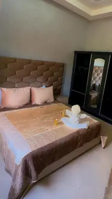 a bedroom with a large bed with a mirror at Villa bnssasi in Marrakech