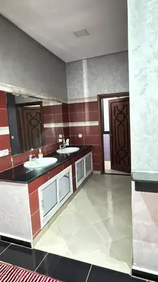 a large bathroom with two sinks and a mirror at Villa bnssasi in Marrakech