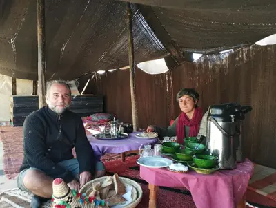 a man and woman sitting at a table in a tent at Auberge Palacio Sidi Hamza in Tazrouft