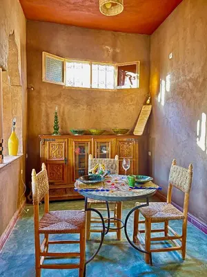 a dining room with a table and two chairs at Dar Zitoune - Authentic Stay in Tagounite in Tagounite