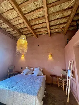 a bedroom with a large bed and a wooden ceiling at Dar Zitoune - Authentic Stay in Tagounite in Tagounite