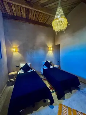 a bedroom with two beds and a chandelier at Dar Zitoune - Authentic Stay in Tagounite in Tagounite