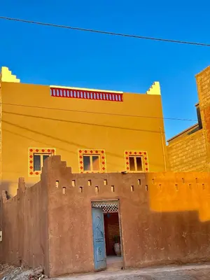 a yellow building with a door in front of it at Dar Zitoune - Authentic Stay in Tagounite in Tagounite