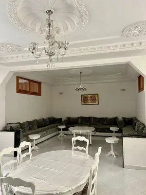 a living room with a table and chairs and a chandelier at Large 3 Bedrooms Medina center Parking Secure in Fès