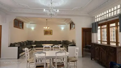 a living room with a table and chairs and a couch at Large 3 Bedrooms Medina center Parking Secure in Fès