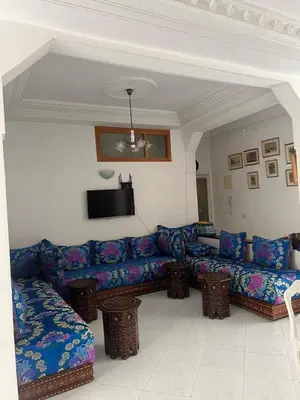 a living room with a blue couch and a tv at Large 3 Bedrooms Medina center Parking Secure in Fès