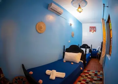 a blue room with a bed with crosses on it at Riad misk lile fez in Fès