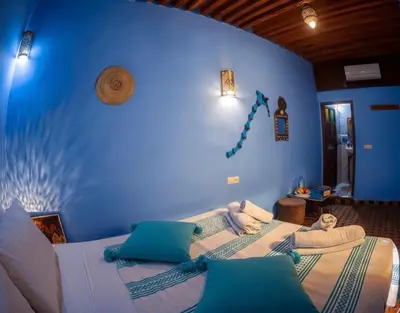 a bedroom with a blue wall with a bed with pillows at Riad misk lile fez in Fès