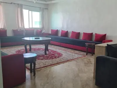 a living room with a blue couch with red pillows at Luxury Apartment in Fes City Centre for Families in Fès