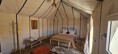 a bedroom with a bed in a tent at Sunlight Desert Camp in Mhamid