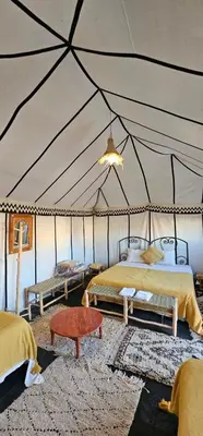 a room with two beds in a tent at Sunlight Desert Camp in Mhamid