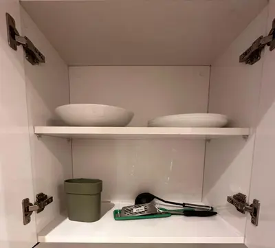 a kitchen shelf with bowls and a green bucket at Relax Family 12 - Cozy Entire Apartment in City Center in Ouarzazate