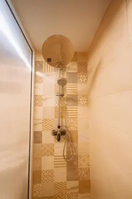 a shower with a shower head in a bathroom at Relax Family 12 - Cozy Entire Apartment in City Center in Ouarzazate