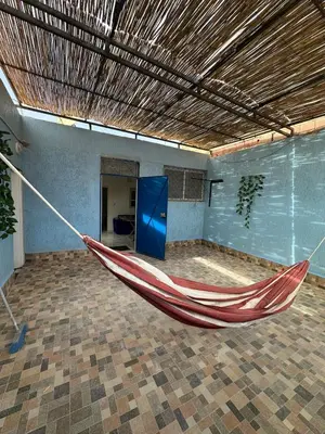 a red hammock in a room with a blue door at A unique and cute apartment in a prime location in Er Rachidia